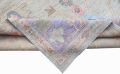 A handwoven transitional Oushak rug with a floral pattern in soft, contemporary colors.