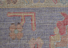 A close-up view of a handwoven wool rug featuring a transitional pattern in muted tones.
