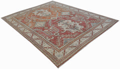 A handwoven transitional Oushak rug featuring a traditional floral pattern in red and cream tones.