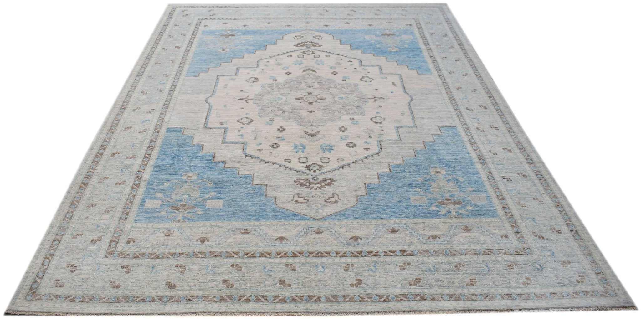 A handwoven transitional Oushak rug featuring a blue and cream floral medallion pattern.