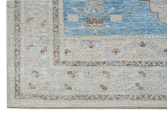 A handwoven transitional Oushak rug featuring a blue central field with floral patterns.