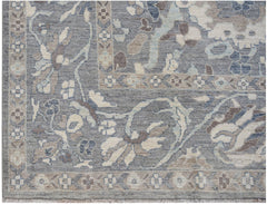 A handwoven transitional Oushak rug featuring a floral pattern in shades of blue, grey, and cream.
