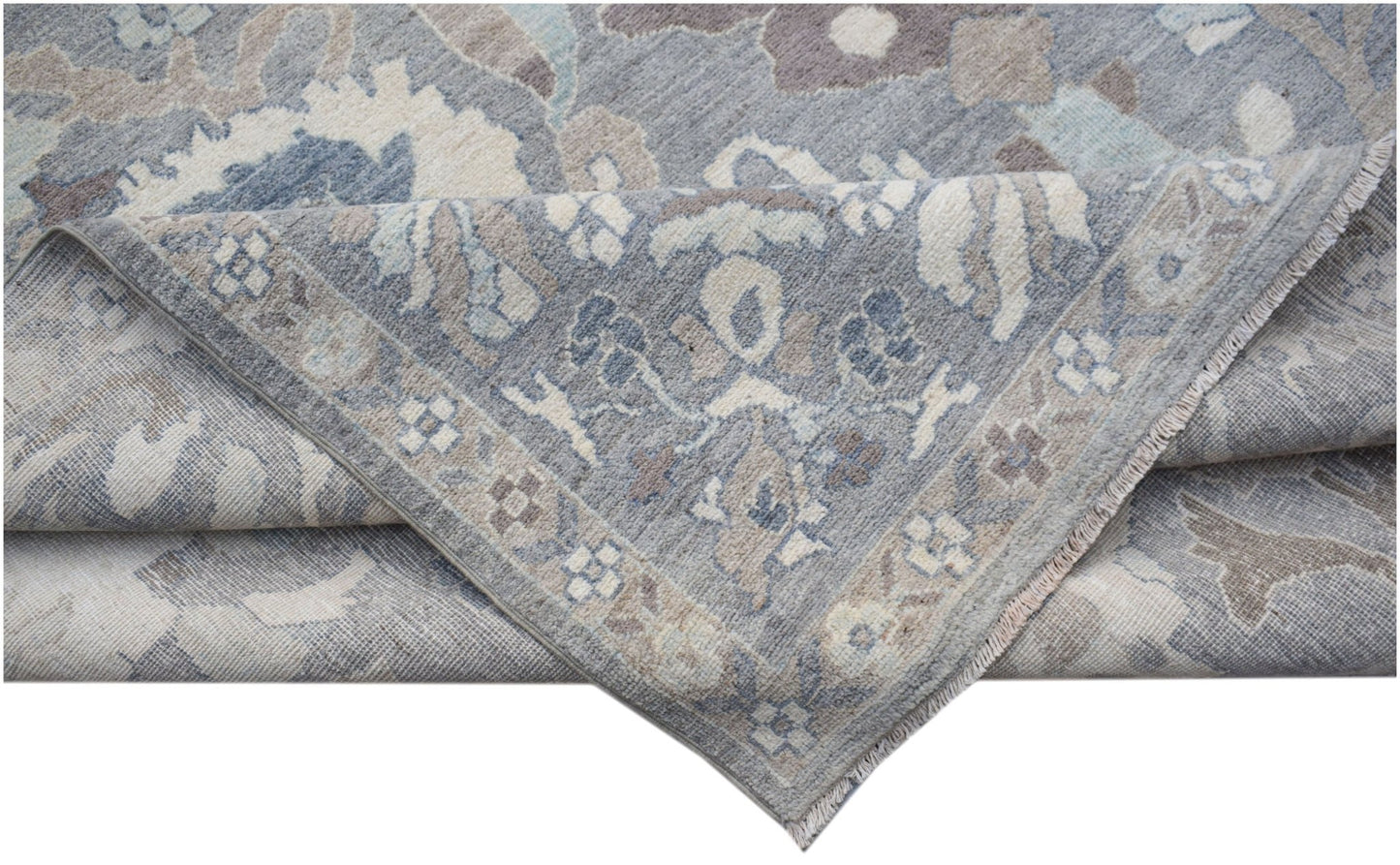 A handwoven transitional Oushak rug in shades of blue and grey with a floral pattern.