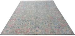 A handwoven transitional Oushak rug featuring a floral pattern in blue, pink, and cream tones.