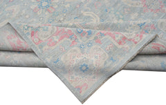 A handwoven transitional Oushak rug featuring a floral pattern in soft blue, pink, and cream tones.