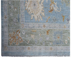 Handmade Afghan Oushak rug featuring a traditional floral pattern in blue, green, and tan tones.