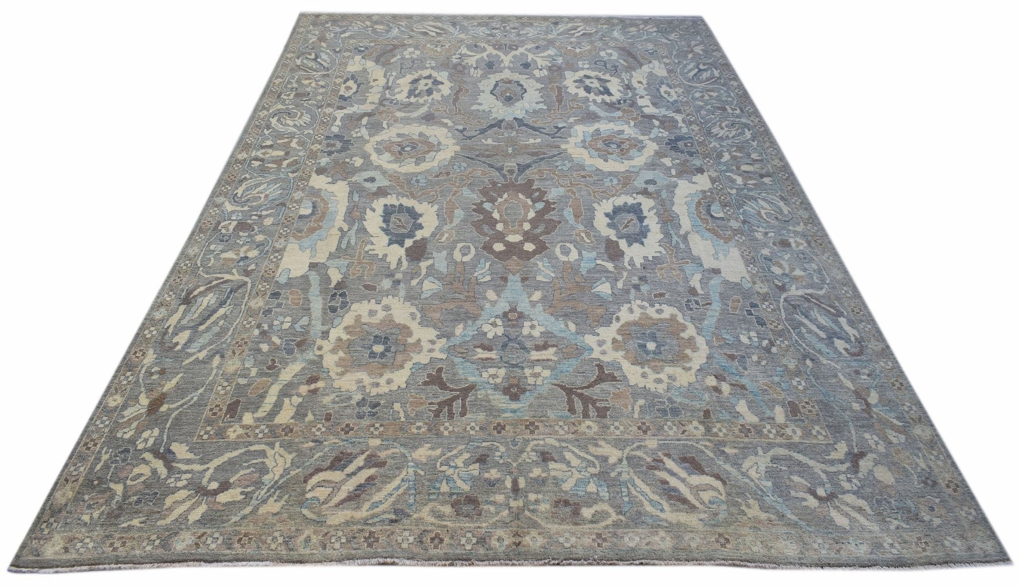 A handwoven transitional Oushak rug featuring a floral pattern in shades of blue, grey, and beige.
