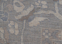 A handwoven transitional Oushak rug featuring a floral pattern in muted blue and beige tones.