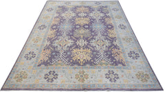 A handwoven transitional Oushak rug featuring a floral pattern in purple, blue, and yellow tones.