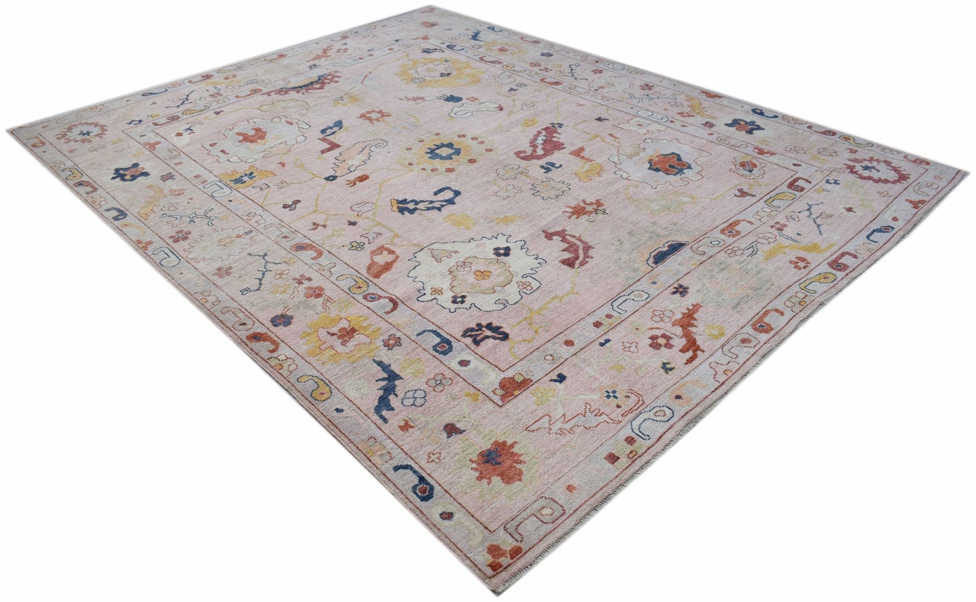 A handwoven transitional Oushak rug featuring a floral pattern in soft, contemporary colors.