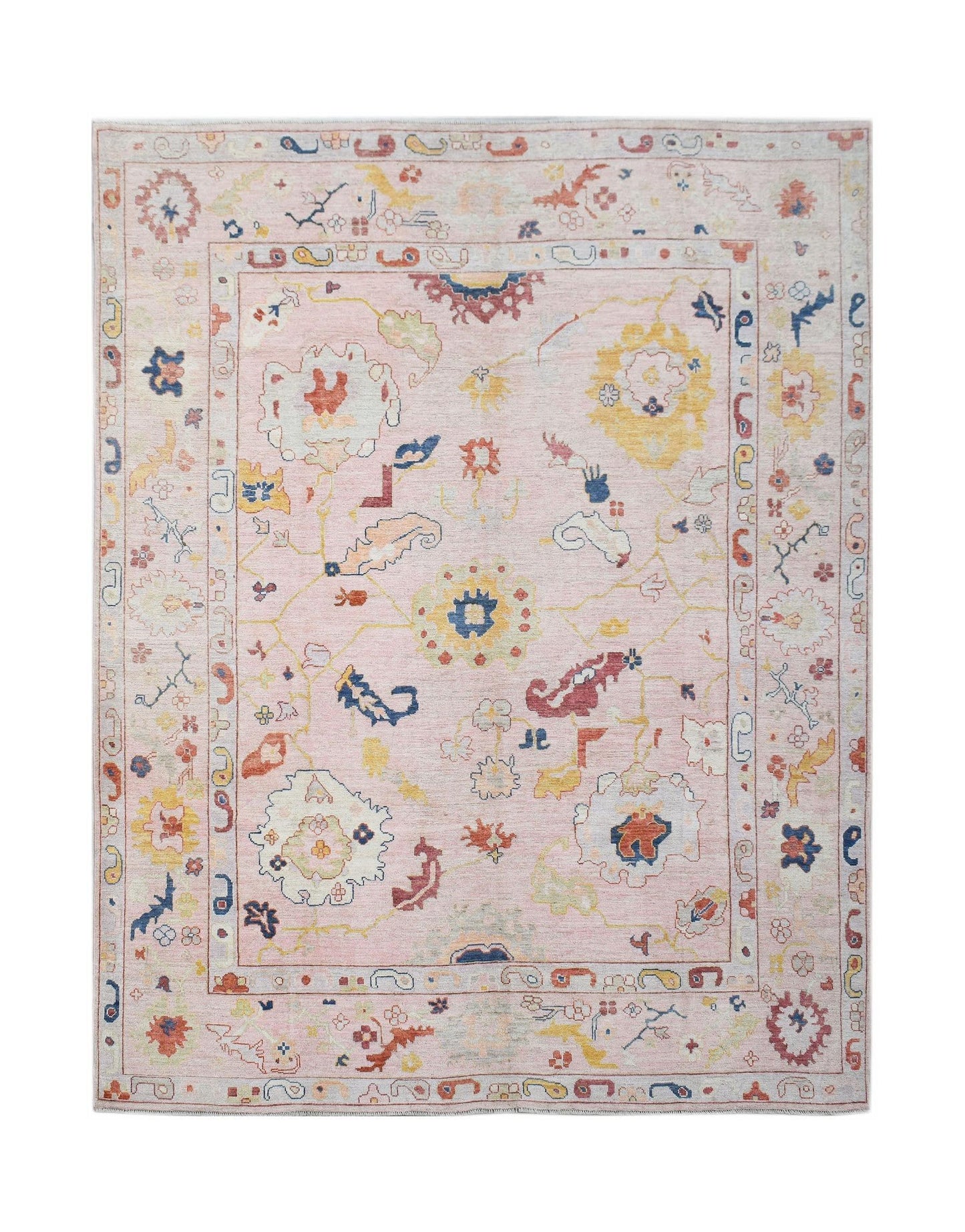 A handwoven transitional Oushak rug featuring a floral pattern in soft pink and multi-colored tones.