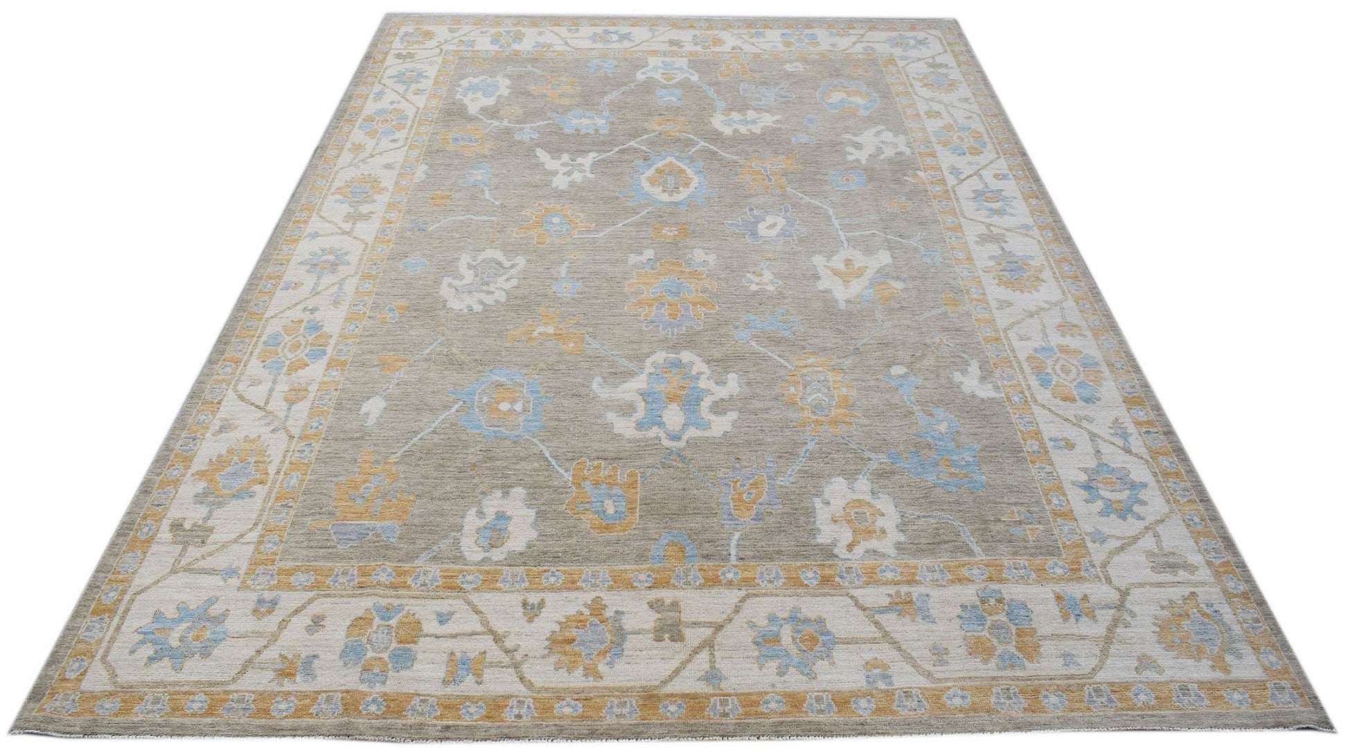 A handwoven transitional Oushak rug featuring a floral pattern in blue and gold on a grey field.