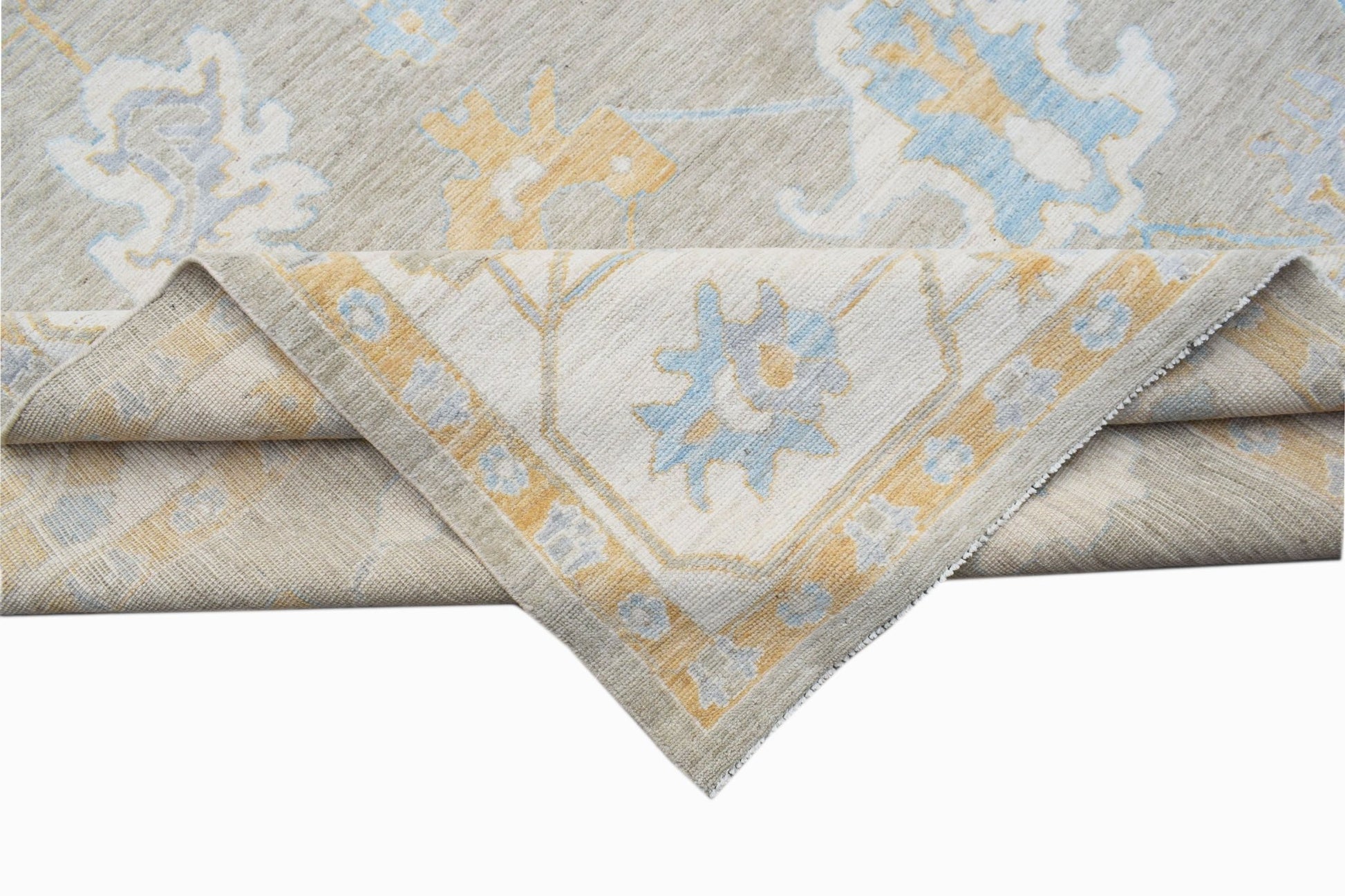 A handwoven transitional Oushak rug featuring a floral pattern in soft blue and yellow tones.