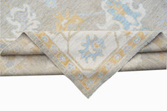 A handwoven transitional Oushak rug featuring a floral pattern in soft blue and yellow tones.
