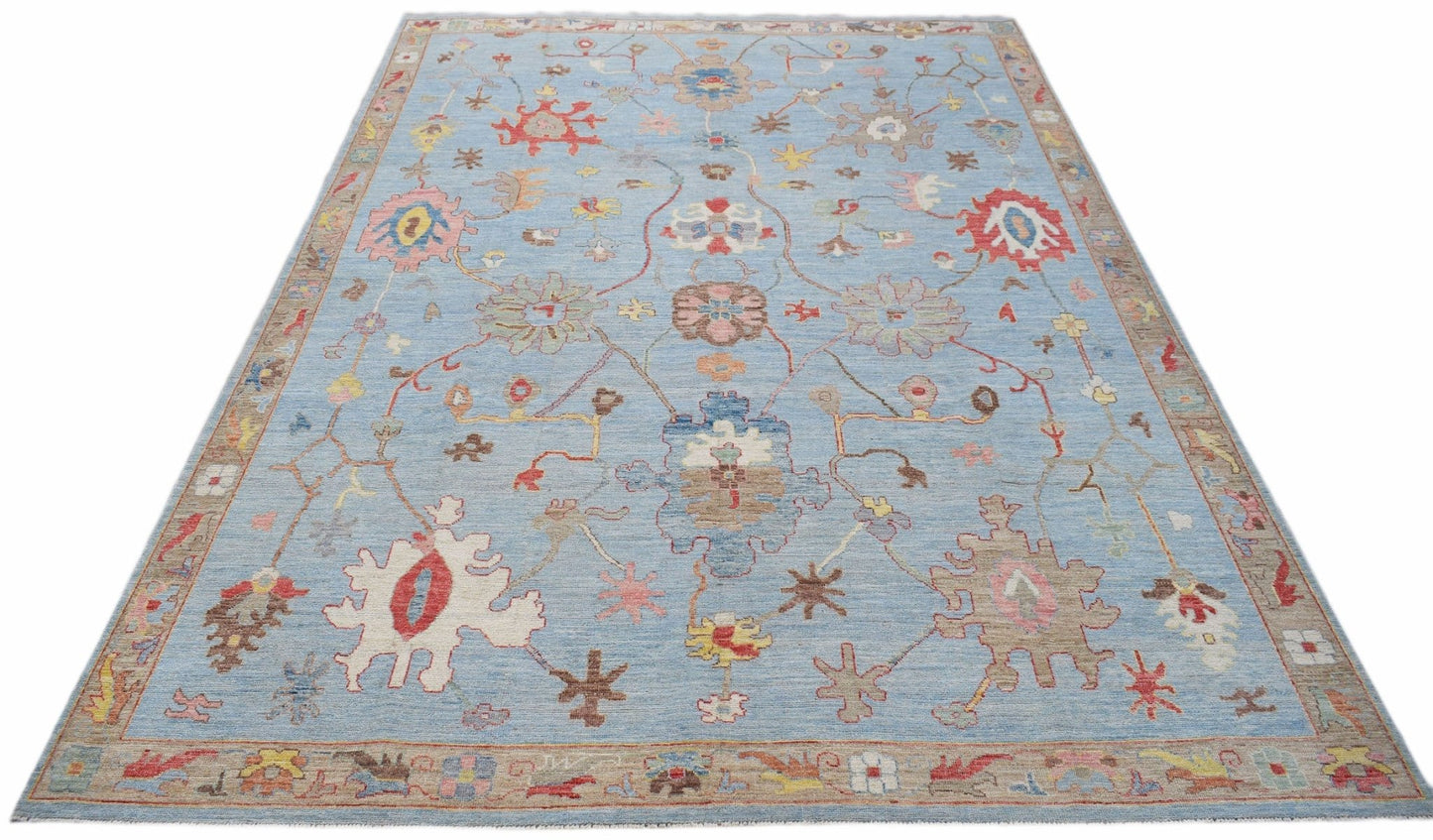 A handwoven transitional Oushak rug featuring a floral pattern on a light blue background.