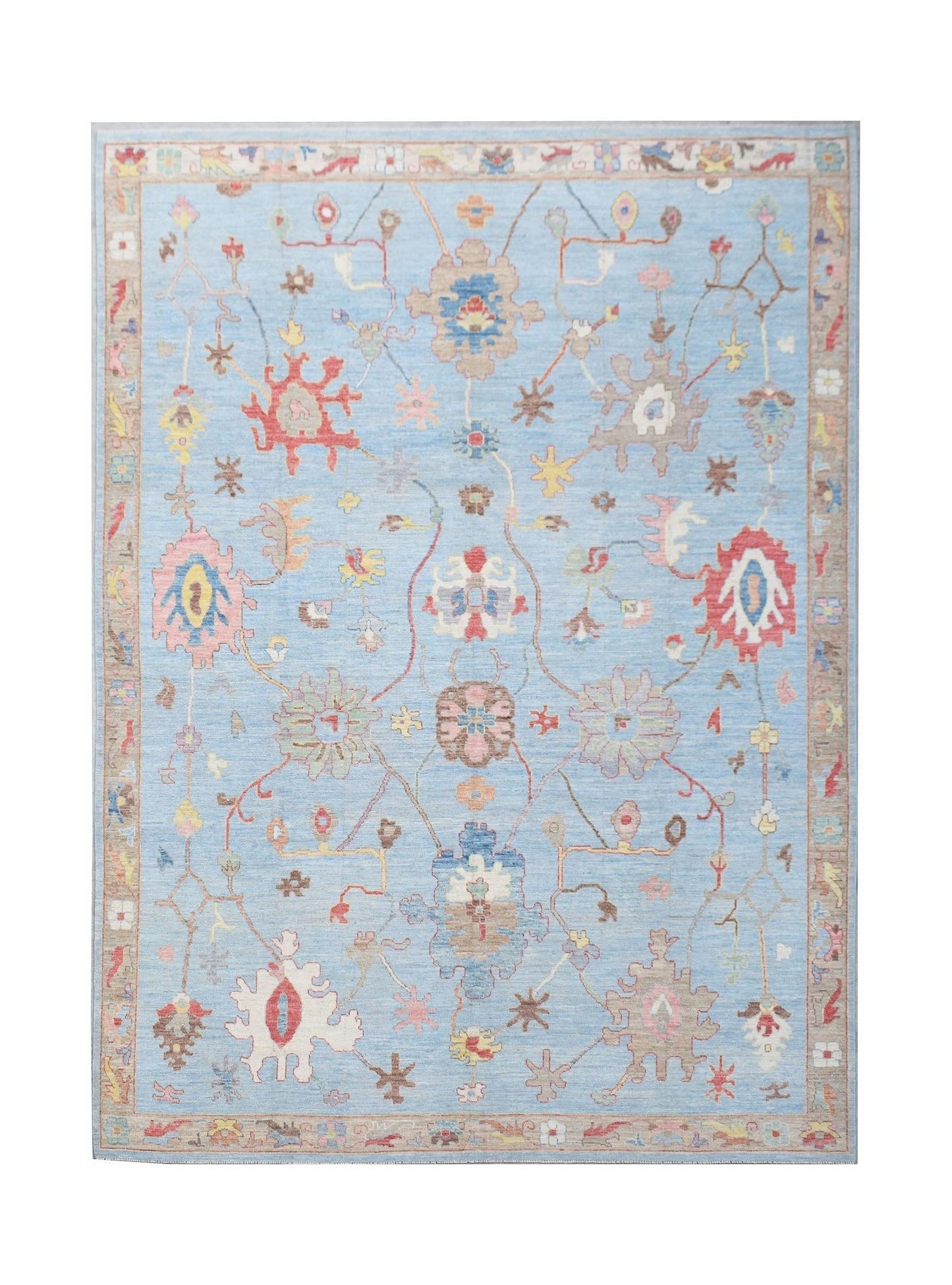 A handwoven transitional Oushak rug featuring a floral pattern on a light blue background.