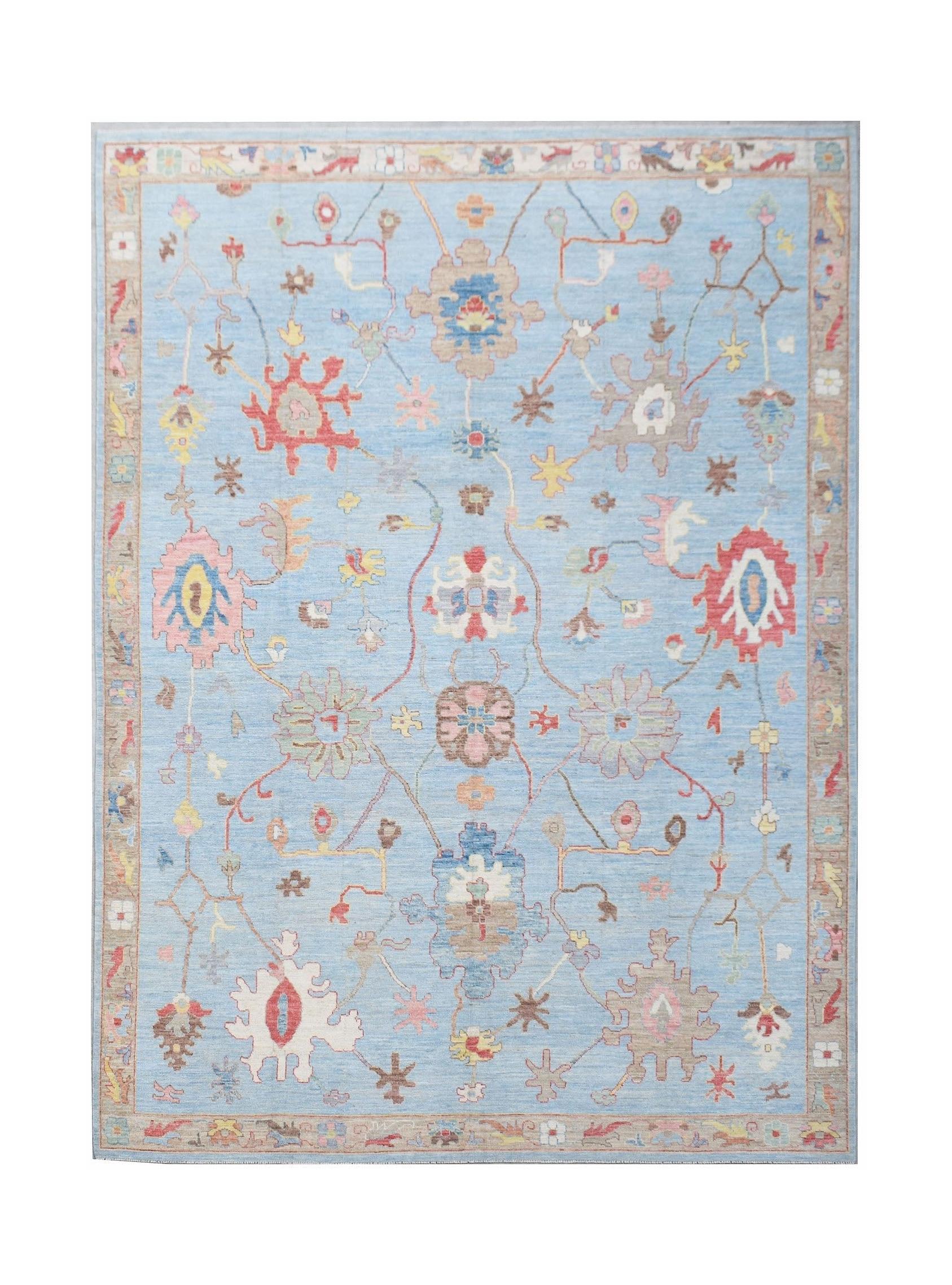 A handwoven transitional Oushak rug featuring a floral pattern on a light blue background.