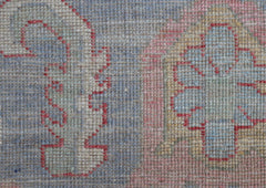 A close-up view of a handwoven transitional Oushak rug featuring a floral pattern in soft tones.