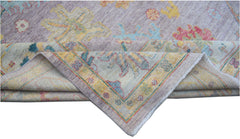 A handmade Afghan Oushak rug featuring a traditional floral pattern in soft, multicolored tones.