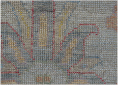 A close-up view of a handmade Afghan Oushak rug featuring a traditional pattern in muted tones.