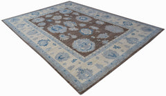 A handwoven transitional Oushak rug featuring a brown field with blue and cream floral patterns.