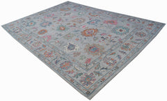 A handwoven transitional Oushak rug featuring a floral pattern in soft, multi-colored tones.