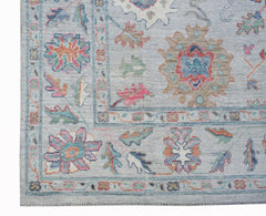 A handwoven transitional Oushak rug featuring a floral pattern in soft, contemporary colors.