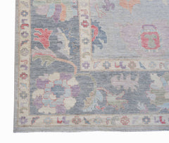 A handwoven transitional Oushak rug featuring a floral pattern in soft blue and pastel tones.