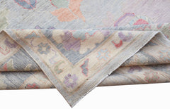 A handwoven transitional Oushak rug featuring a floral pattern in soft pastel tones.