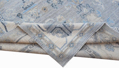 A handwoven transitional Oushak rug featuring a floral pattern in shades of blue and beige.