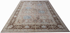 A handmade transitional Oushak rug featuring a brown and blue patterned design on wool.