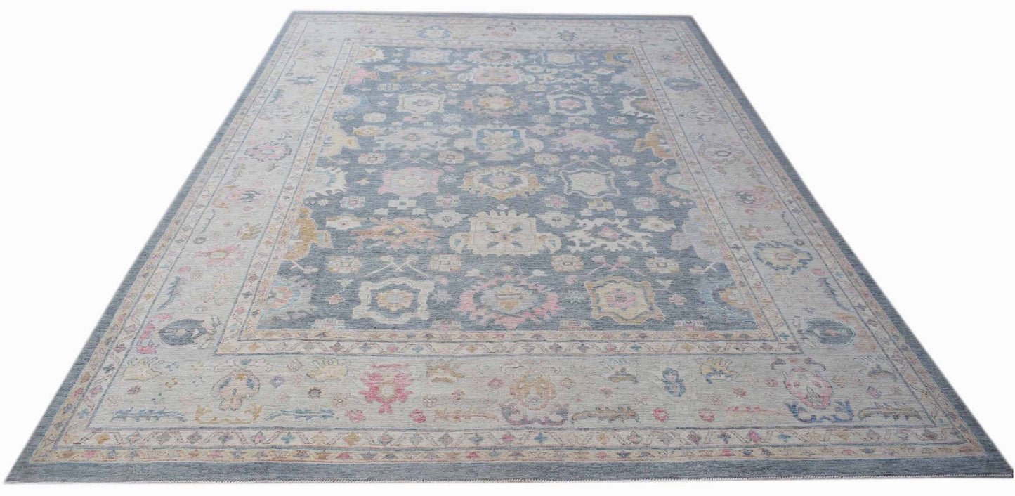 A handwoven transitional Oushak rug featuring a floral pattern in blue, pink, and cream tones.