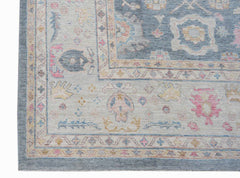 A handwoven transitional Oushak rug featuring a floral pattern in soft blue, pink, and cream tones.