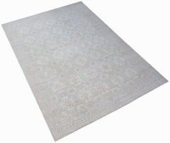 A handwoven transitional Oushak rug featuring a light floral pattern in soft neutral tones.