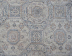 A handwoven transitional Oushak rug featuring a geometric floral pattern in soft neutral tones.
