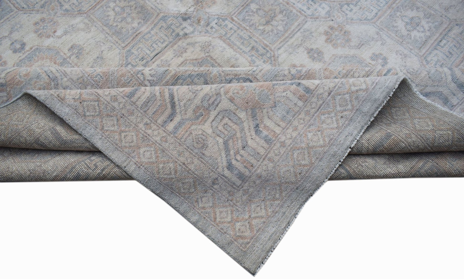 A handwoven transitional Oushak rug featuring a muted floral pattern in soft blue and beige tones.