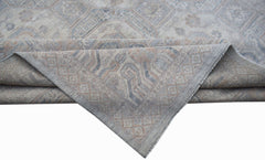 A handwoven transitional Oushak rug featuring a muted floral pattern in soft blue and beige tones.