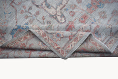 A handwoven transitional Oushak rug featuring a floral pattern in soft blue and red tones.