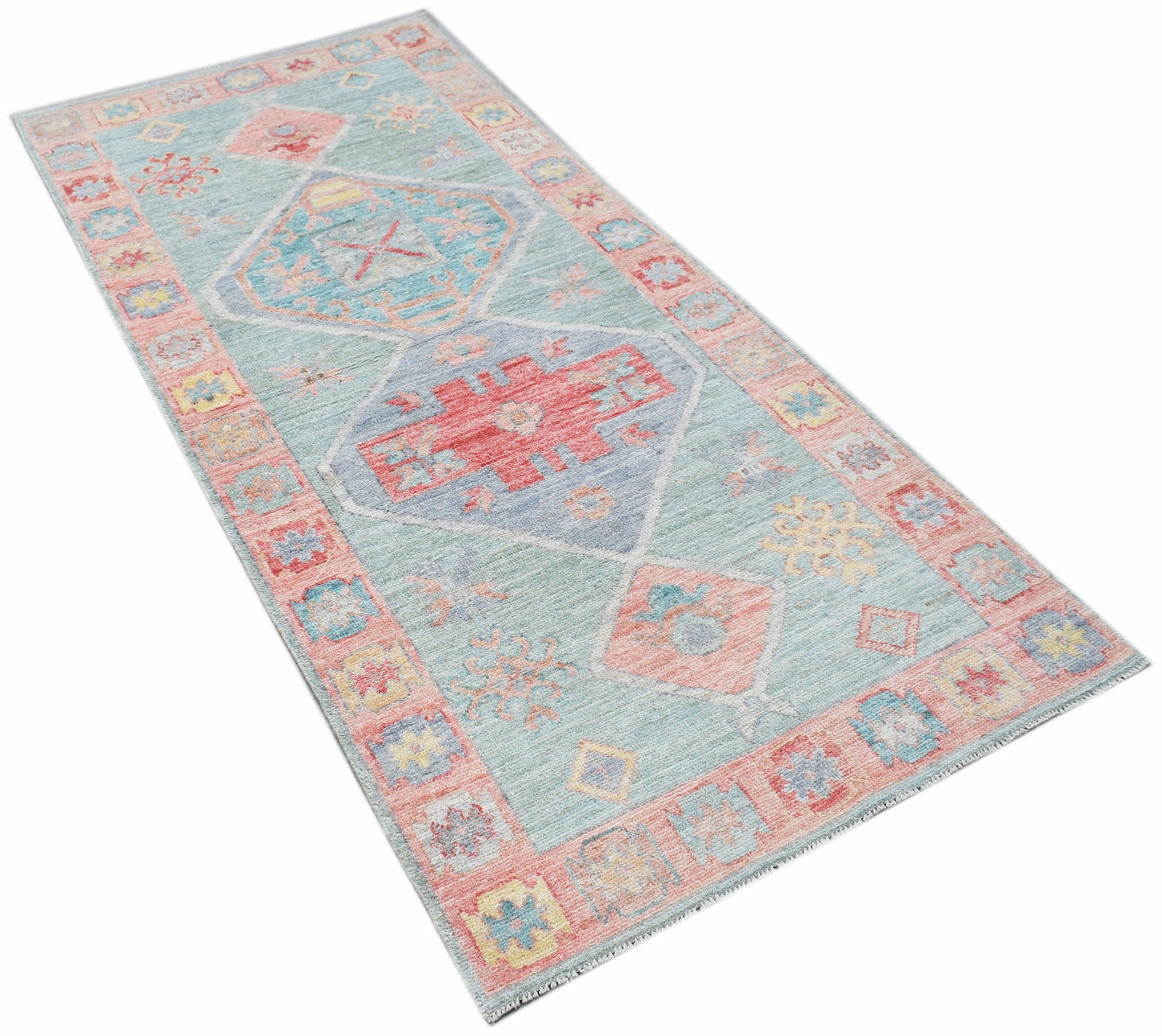 A handwoven transitional Oushak runner featuring a geometric pattern in blue, red, and yellow.
