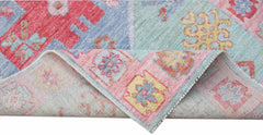 A handwoven transitional Oushak runner featuring a colorful floral pattern in wool.