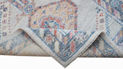 A handwoven transitional Oushak runner featuring a floral pattern in blue, pink, and beige tones.