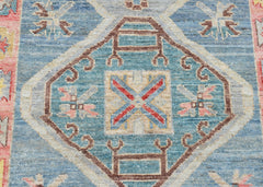A handwoven transitional Oushak runner featuring a blue central medallion with geometric patterns.
