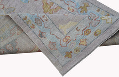 A handwoven transitional Oushak runner featuring a floral pattern in soft blue and muted tones.