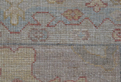 A close-up view of a handwoven wool runner rug featuring a soft floral pattern in muted tones.
