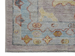 A handwoven transitional Oushak runner featuring a floral pattern in soft blue and muted tones.