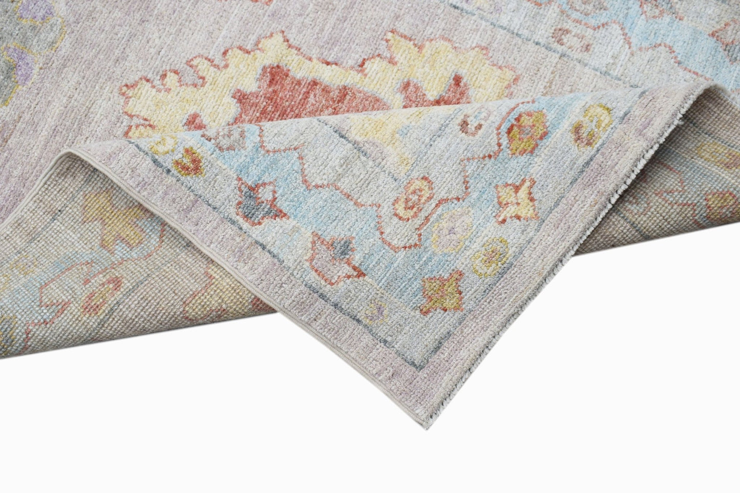 A handwoven transitional Oushak runner featuring a floral pattern in soft pastel tones.