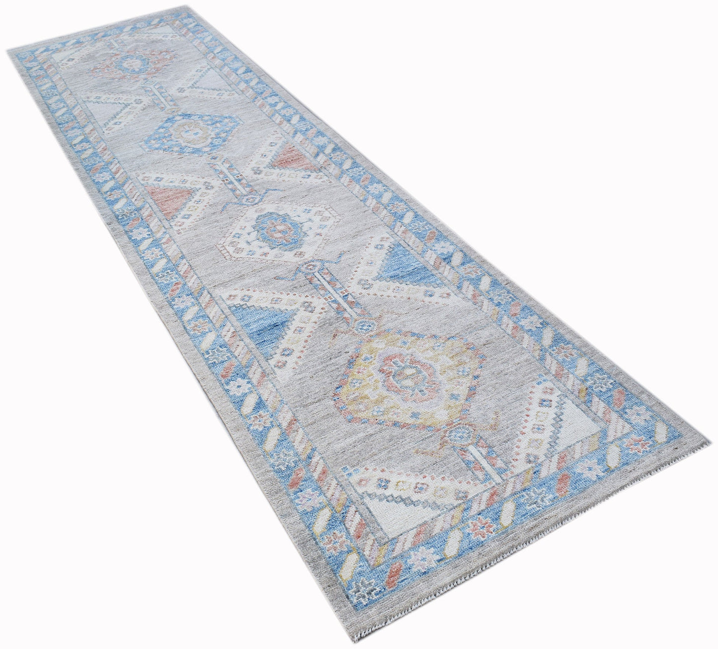 A handwoven transitional Oushak runner rug featuring a floral pattern in blue, grey, and soft tones.