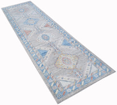 A handwoven transitional Oushak runner rug featuring a floral pattern in blue, grey, and soft tones.