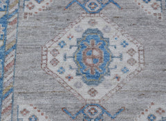 A handwoven wool runner featuring a transitional Oushak pattern in blue, grey, and soft pink tones.