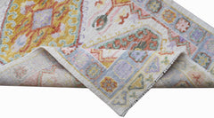A handwoven transitional Oushak runner featuring a floral pattern in soft, multi-colored tones.
